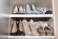 Shelves with woman old used shoes collection, standing messy in wardrobe, closet Royalty Free Stock Photo