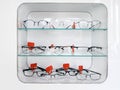 Shelving with glass shelves with glasses and frames in the optics store to improve vision and correct eyes. Ophthalmology and heal