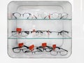 Shelving with glass shelves with glasses and frames in the optics store to improve vision and correct eyes. Ophthalmology and heal