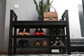 Shelving unit with stylish shoes and bag near grey wall in hallway, low angle view Royalty Free Stock Photo