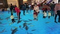 Shenzhen, China: children play happily as decorated fish swim around on the ground