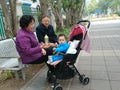 Shenzhen, China: Grandparents and grandchildren rest on the sidewalk