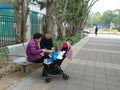 Shenzhen, China: Grandparents and grandchildren rest on the sidewalk