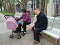 Shenzhen, China: Grandparents and grandchildren rest on the sidewalk