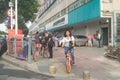 Shenzhen, China: a street view of elderly people waiting for tour buses and women on bicycles