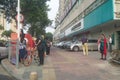 Shenzhen, China: a street view of elderly people waiting for tour buses and women on bicycles