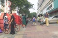 Shenzhen, China: a street view of elderly people waiting for tour buses and women on bicycles