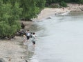 Shenzhen, China: women and children play at the beach or catch crabs.