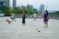 Shenzhen, China: women walk their dogs outdoors and play with their pets.