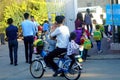 Shenzhen, China: a young father riding a bicycle carrying a little girl home from kindergarten