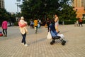 Shenzhen, China: Young mothers or grandmothers play outdoors with their children