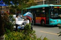 Shenzhen, China: a young woman riding an electric car chats with a man on the road