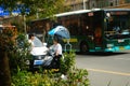 Shenzhen, China: a young woman riding an electric car chats with a man on the road