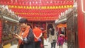 Shenzhen, China: young women burn incense and worship at the beidi temple