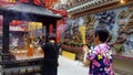 Shenzhen, China: young women burn incense and worship at the beidi temple