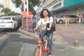 Shenzhen, China: a street view of elderly people waiting for tour buses and women on bicycles