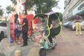 Shenzhen, China: a street view of elderly people waiting for tour buses and women on bicycles