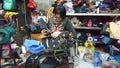 Shenzhen, China: women mend leather shoes. It costs 60 yuan to change the soles of leather shoes.
