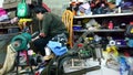 Shenzhen, China: women mend leather shoes. It costs 60 yuan to change the soles of leather shoes.