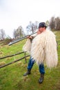 Shepherd dressed in traditional wool costume, calling sheep at the farm in Transylvania Roumania