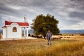 A shepherd in front of a little chapel and a herd of sheep Royalty Free Stock Photo