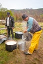 Shepherd preparing milk for cheese making at the farm in Transylvania Roumania