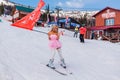 Sheregesh, Kemerovo region, Russia - April 12, 2019: Young happy pretty woman in pink on snow slope riding mountain ski