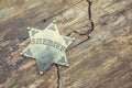 Sheriff badge on wooden background.