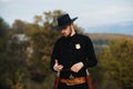 Sheriff or cowboy in black suit. Man with vintage pistol revolver and marshal ammunition. American western Sheriff. Wild