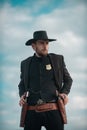 Sheriff officer in black suit and cowboy hat. Man with wild west guns, vintage pistol revolver and marshal ammunition Royalty Free Stock Photo