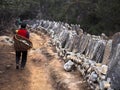 Sherpa Porter Walking on Trail Next to Tibetan Mani Stones Royalty Free Stock Photo