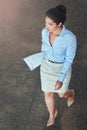 Shes ahead of the pack. High angle shot of a confident young businesswoman walking across an office floor.