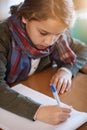 Shes all about finishing her schoolwork. an elementary school girl doing her school work in the classroom. Royalty Free Stock Photo