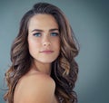 Shes a blue-eyed beauty. Cropped portrait of a beautiful young woman posing against a grey background in the studio. Royalty Free Stock Photo