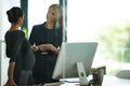 Shes a busy businesswoman and expecting. a pregnant businesswoman and a colleague talking together in an office.