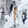 Shes a calm amongst the office storm. Portrait of a young professional standing on a stairs with colleagues rushing