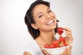 Shes chosen the healthy alternative. Portrait of a young woman enjoying a bowl of strawberries. Royalty Free Stock Photo