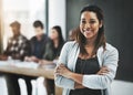 Shes confident about her teams abilities. Portrait of a cheerful businesswoman posing with her arms folded in a modern Royalty Free Stock Photo