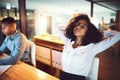 Shes conquered the night shift. a young businesswoman relaxing at her desk while working alongside her colleague in an Royalty Free Stock Photo