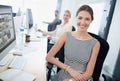 Shes the consummate professional. Portrait of a young office worker sitting at her workstation in an office.