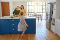 Shes definitely excited for a healthy meal. a little girl dancing while her mother and grandmother cooks in the