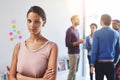 Shes determined to reach her goals. Portrait of a young businesswoman with her colleagues standing in the background.