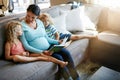 Shes doing a great job as a mom. a pregnant woman spending time with her children at home.