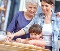 Shes doing it perfectly. a three generational family baking together.