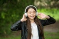 Shes ear for music. Happy child wear ear phones outdoors. Small girl listen to music in headphones. Comfortable ear pads Royalty Free Stock Photo