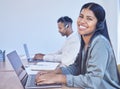 Shes so good at the sales game. Portrait of a young businesswoman wearing a headset while using a laptop in an office. Royalty Free Stock Photo