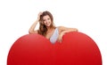 Shes got a big heart. Portrait of an attractive young woman standing behind a giant heart-shaped prop.