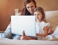 Shes got a curious young mind. a mother and her little daughter using a laptop together at home. Royalty Free Stock Photo