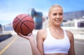 Shes got game. Cropped view of a female basketball player with a cityscape in the background.