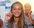 Shes got an inquisitive mind. Portrait of an enthusiastic schoolgirl raising her hand to answer a question in class. Royalty Free Stock Photo